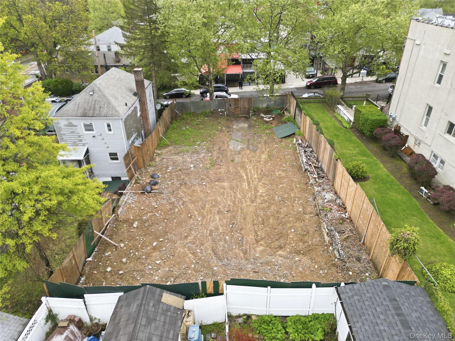Spacious cleared lot featuring privacy fencing and surrounding mature trees