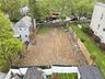 Spacious cleared lot featuring privacy fencing and surrounding mature trees