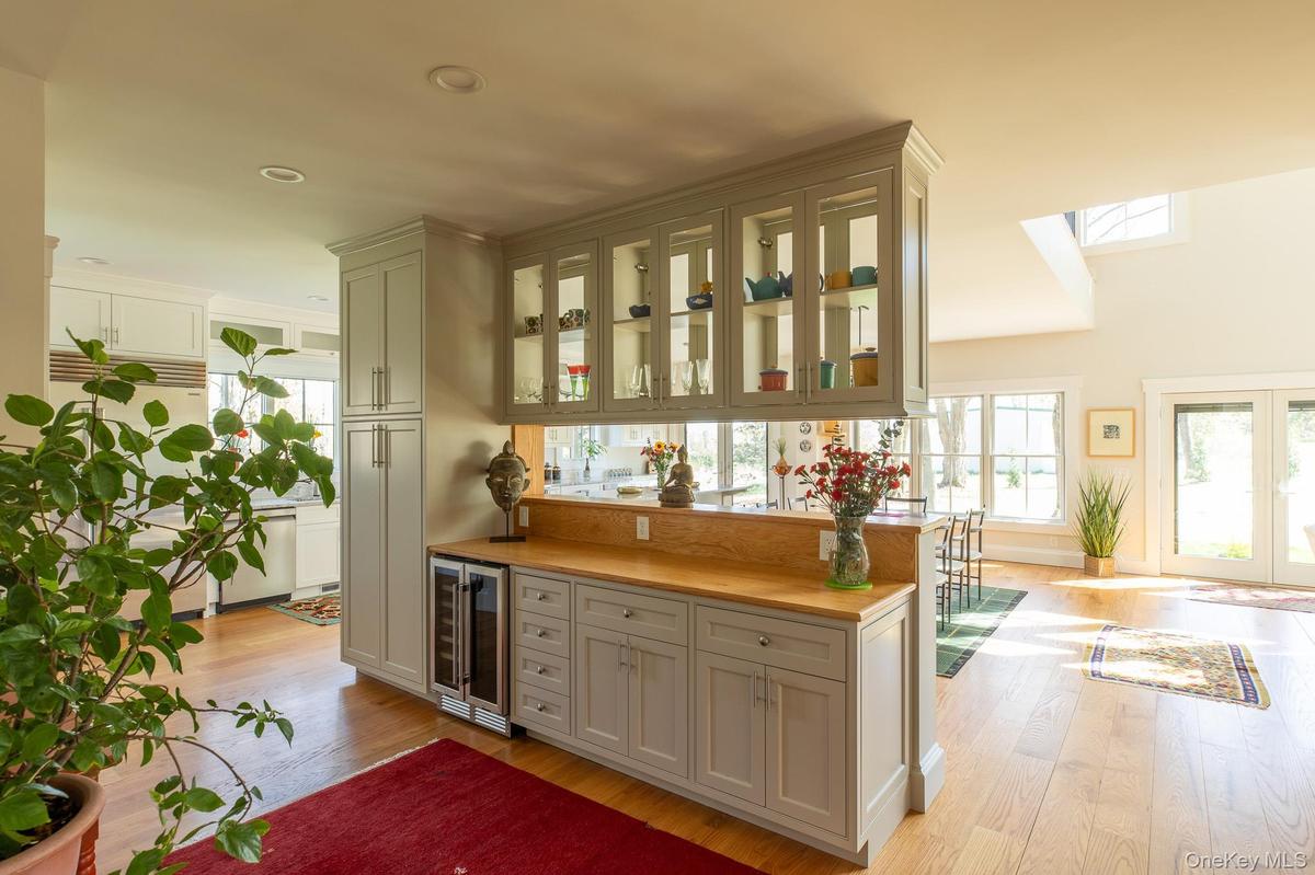 Wet bar with beverage fridge and glass cabinets