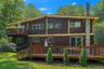 Multi-level exterior featuring brown vertical siding, yellow trim, and multiple windows