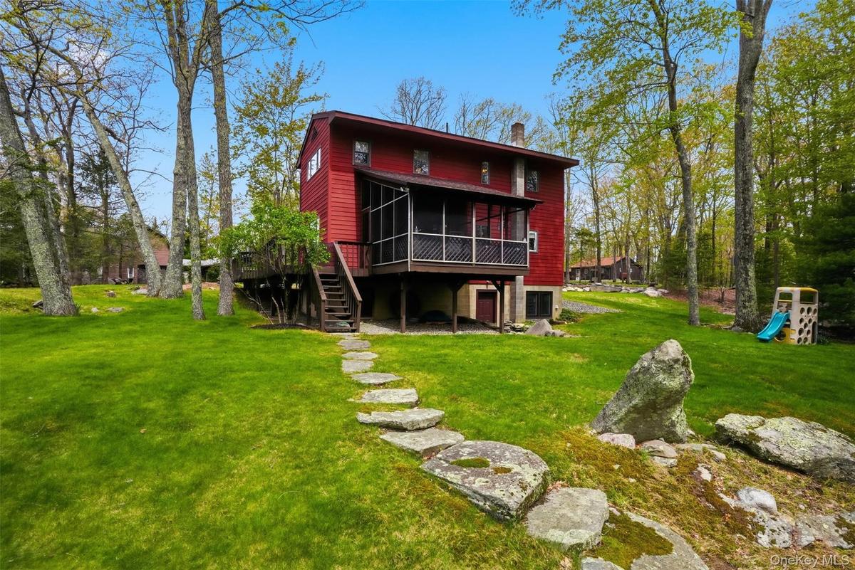 View of expansive green lawn and screened in porch.