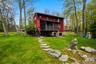 View of expansive green lawn and screened in porch.