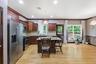 Kitchen featuring a granite-topped island, light wood-finish flooring, recessed lighting, and stainless steel appliances