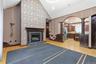 Vaulted ceiling featuring a decorative accent wall and a built-in fireplace with a dark wood mantel