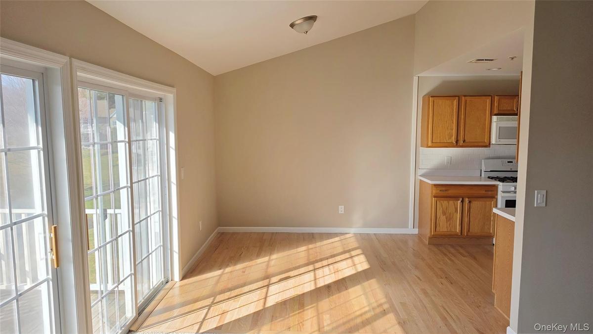 Dining Room open to living room and kitchen with French door style slider to balcony