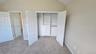 Second bedroom showcasing large closet with cabinet system