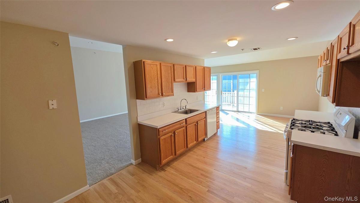 View of kitchen from dining area with doorway leading to living room