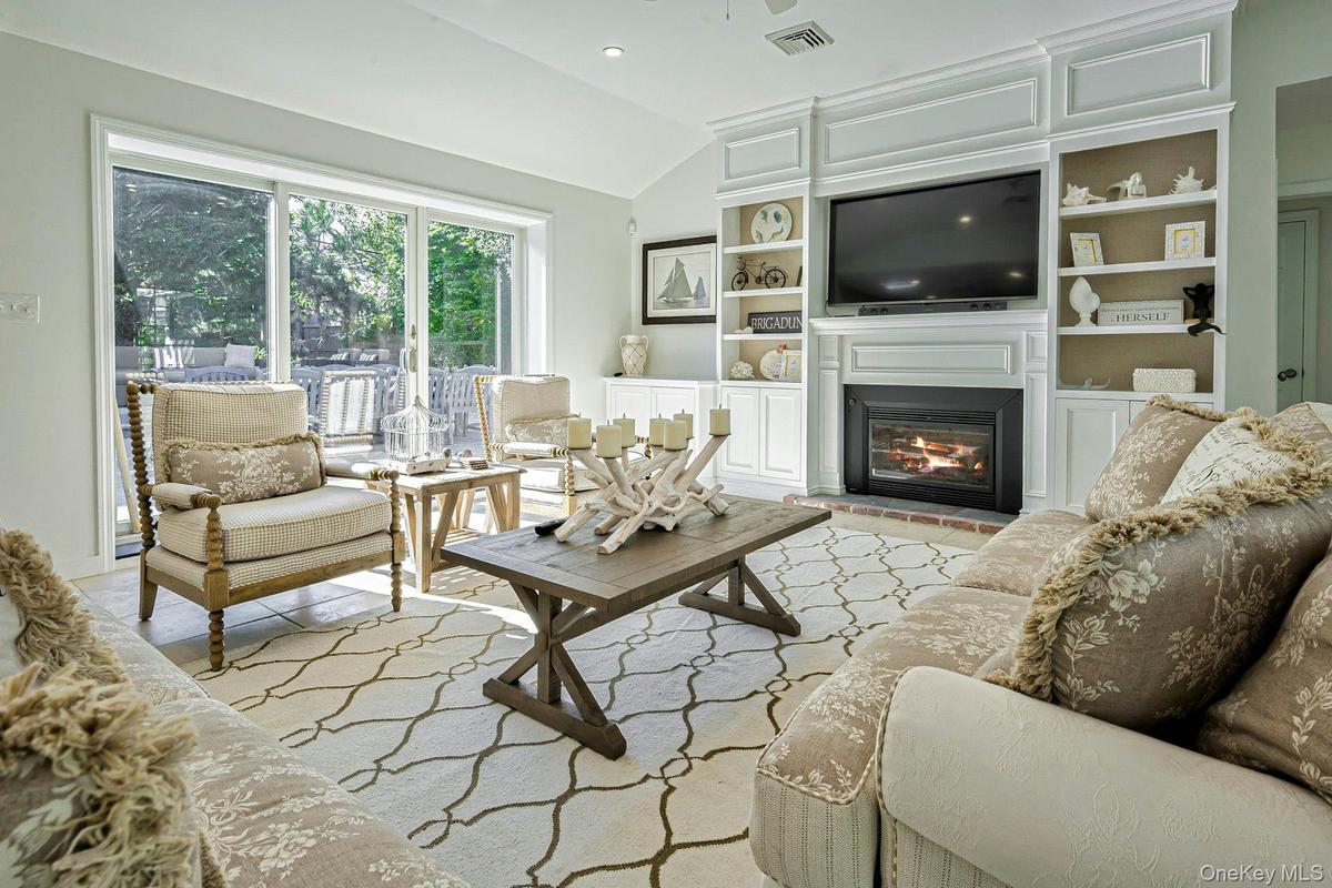 Living area featuring a vaulted ceiling and sliding glass doors to the exterior