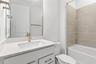 Fresh bathroom with upgraded finishes, bright cabinetry, and a tub/ shower.