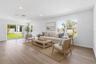 Virtually staged living space with warm wood look floors and an easy open layout.