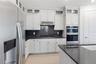 Modern kitchen with bright cabinetry, sleek counters, and a finished design center feel.