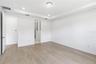 Spacious bedroom with warm flooring, bright walls, and flexible furniture options.