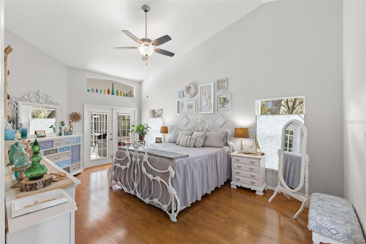 Primary bedroom with french doors leading out to the pool area