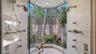 Glass-enclosed “outdoor” shower that offers breathtaking views of the outdoors featuring dual his-and-her shower heads, allowing both style and functi