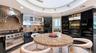 Professional-grade range, custom cabinetry, and kitchen layout leading to a walk-in pantry and laundry room