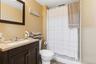 Basement Bathroom featuring a vanity with a light-colored countertop, dark wood-finish cabinetry, and a chrome faucet