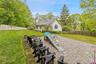 Expansive paver patio bordered by a low retaining wall and a large grassy yard