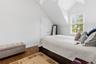 Room #1 with a sloped ceiling, wood-finish flooring, white walls, and a large window with blinds