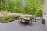 Spacious outdoor deck featuring an integrated outdoor kitchen with a built-in pizza oven, grill, and stone-clad base