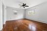Spacious room featuring rich wood-finish flooring, light gray wall paint, and white trim