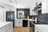 The ceramic and stone backsplash adds a contrast to the quartz countertops as well as the floor.