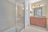 Private bath with granite vanity and glass enclosed shower serving the themed suite