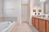 Expansive primary bath featuring dual vanities, soaking tub, and walk-in shower