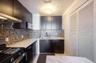 Kitchen with appliances with stainless steel finishes, decorative backsplash, light stone counters, and under cabinet range hood