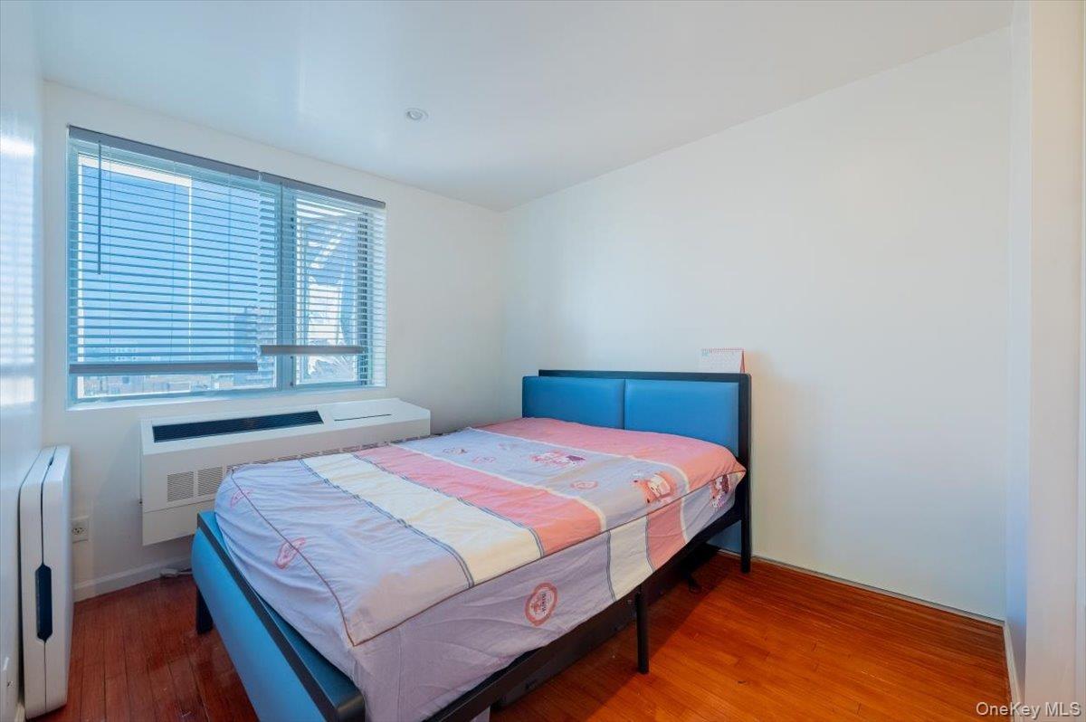 Bedroom featuring wood finished floors and radiator