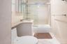 Full bath featuring vanity, tile walls, and combined bath / shower with glass door