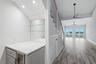 Bar with wine refrigerator and display shelvesadjacent to dining roomK