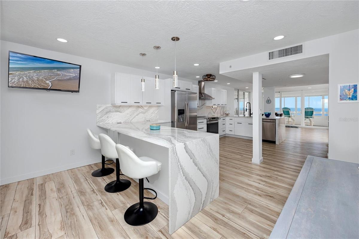 Large kitchen with two bar islands complete with waterfall quartz to the floor