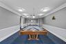 Community game room with a regulation billiards table, lounge seating, and arched architectural details.