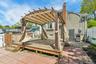 Expansive wood deck with a built-in pergola, offering a dedicated outdoor living space