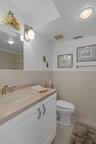 En-suite bath features single vanity with Corian countertop and a storage cabinet + drawer
