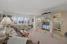 Living Room features windows with plantation shutters across the back as well as access to the patio through a sliding door.