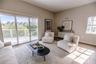 Open concept living and dining room with natural light and balcony overlooking mangroves.