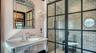 Glass-enclosed shower with marble tile