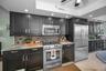 Large Kitchen with charcoal cabinets, stainless steel appliances & Quartz countertops