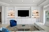 The family room features a beautifully designed entertainment wall with custom built-in cabinetry and integrated media space.