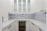 A sophisticated butler's pantry located just off the kitchen offers an expansive prep area for entertaining and includes a wine refrigerator.