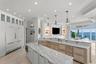 The elegant kitchen showcases stunning Tampa Bay views, custom cabinetry and fully integrated paneled refrigerator.