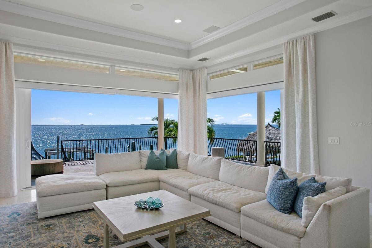 Enjoy stunning waterfront views of Tampa Bay from the family room as the sliding glass doors open completely to the outdoors.