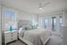 Top-leel bedroom two with French doors opening onto a private balcony.