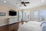 Another view of the main level, primary suite, highlighting the glass sliders, large balcony and views of Tampa Bay.