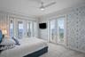 Top level, bedroom three with French doors opening to a breathtaking balcony with ocean views.
