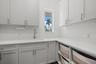 The laundry room has custom cabinetry and quartz counter tops.