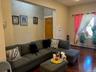 Living space featuring wood-finish flooring, a broad entry portal, and a window with natural light