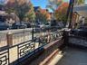 Patio featuring a brick and concrete knee wall with decorative block accents, black metal geometric railings, and a concrete surface