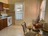 Kitchen area featuring wood-finish cabinetry, a gas range, and a tiled backsplash